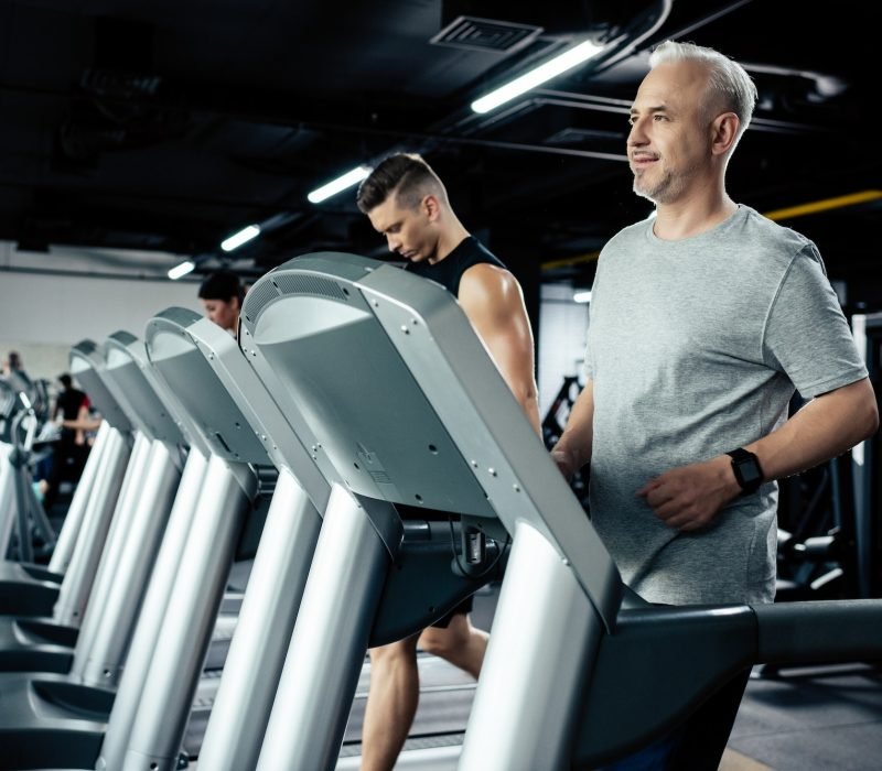 senior-and-young-sportsmen-running-on-treadmills-in-sport-center.jpg